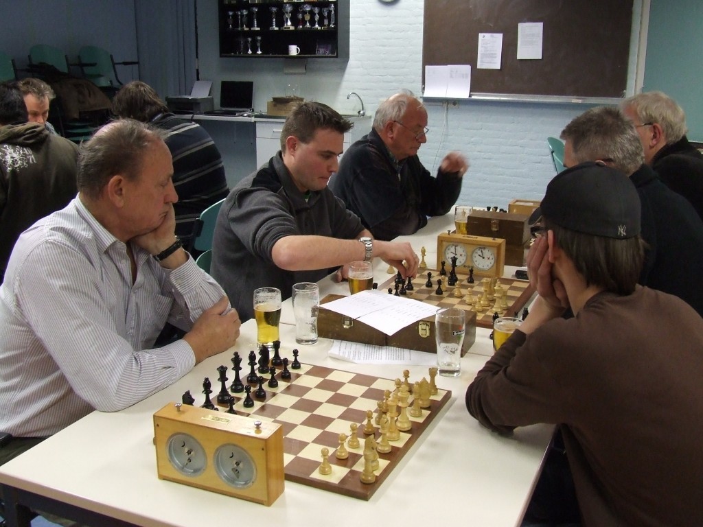 Rob ten Have (derde van links), op de laatste dinsdag van 2008 tegen Arend Stapel spelend tijdens het snelschaakkampioenschap van Caïssa. Hij wordt derde in de finalegroep D; een biertje heeft hij al genomen.