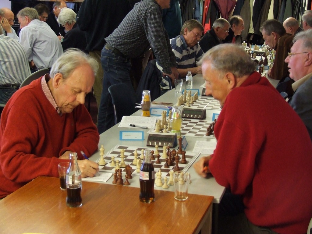 Dolf Teunisse noteert een zet tijdens zijn (gewonnen) partij tegen Pieter Sijtsma, in de tweede ronde van het NHSB-lenteveteranenkampioenschap van 2009.