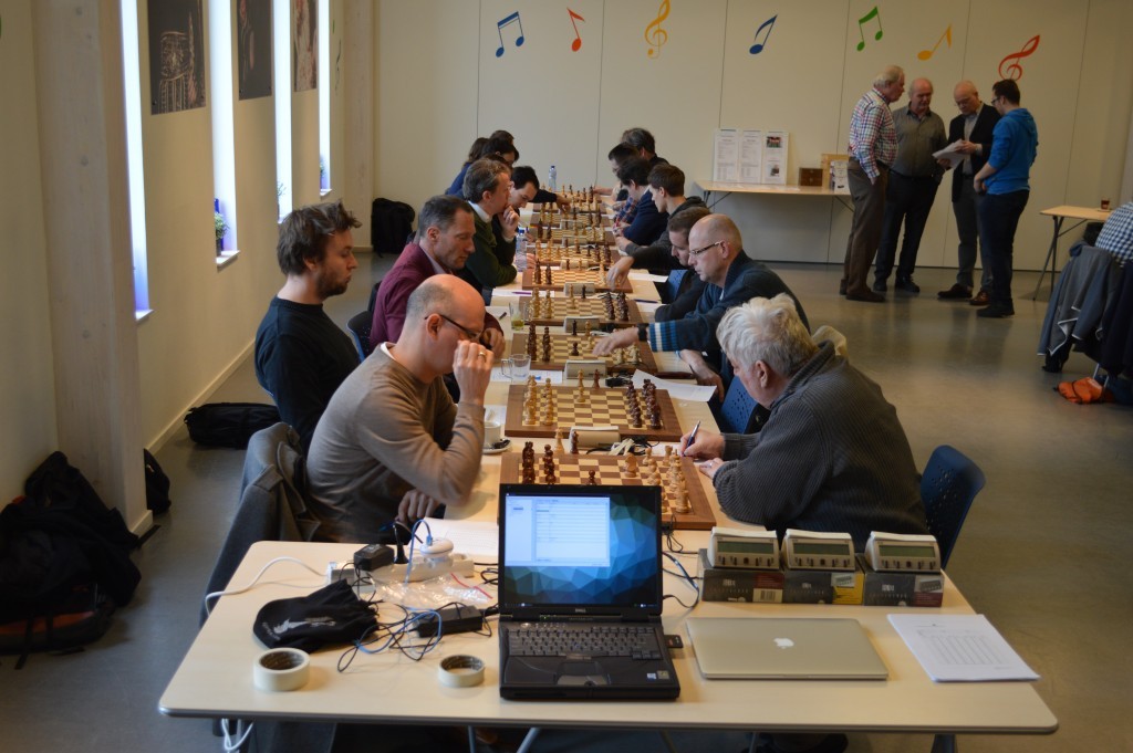 Aan de lange tafel bij de ramen is Caïssa-Eenhoorn - Wageningen begonnen. Vooraan de computer die de liveborden in contact brengt met de wereld.