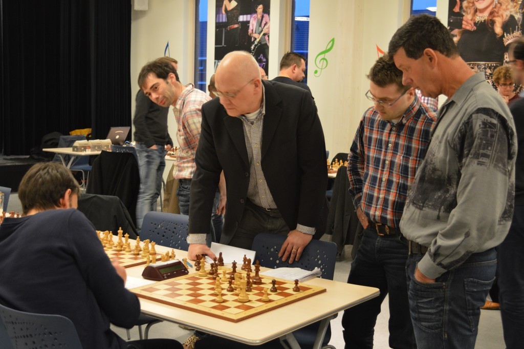 Arbiter Aart Strik controleert of de remiseclaim van Fred Jonker (naast hem) terecht is. De zittende Alexander Geerts kijkt naar zijn slotzet 57. Da6. Rechts Caïssa-Eenhoorn-supporter Arnold van der Wolff.