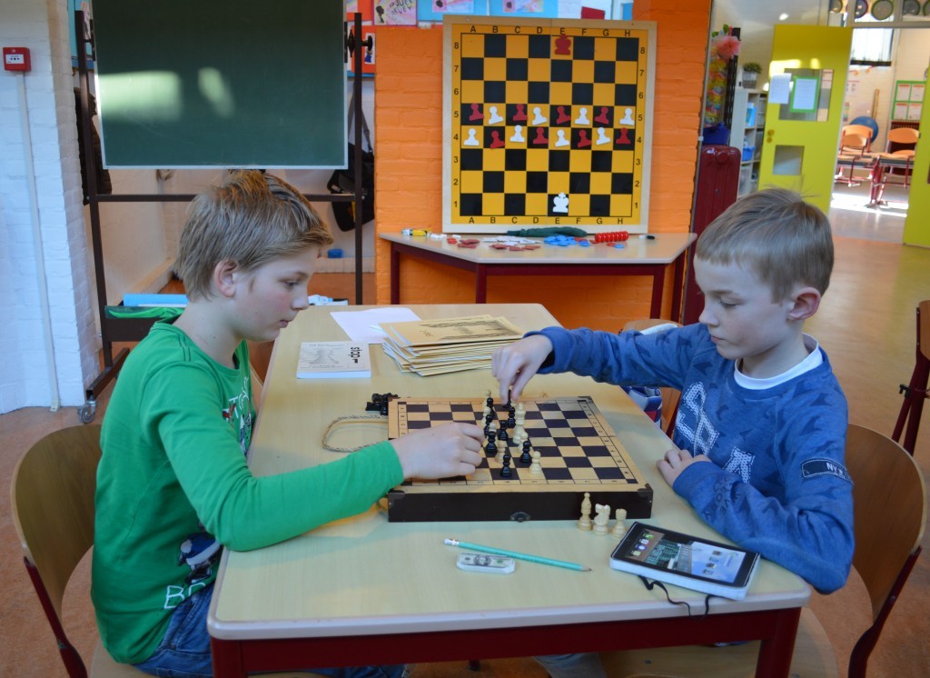 Yuri (links) en Senna schaken. Op het demonstratiebord staat de beginstelling van het spelletje.