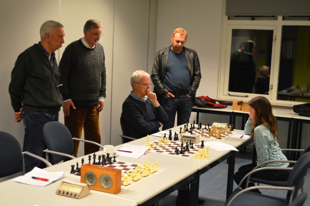 Peter Burink, Kees Kraijo en Eugène Koomen (vlnr) kijken hoe hun ploeggenoot Hans Morsink het doet tegen Robin Duson. De partij aan het eerste bord eindigt in remise.