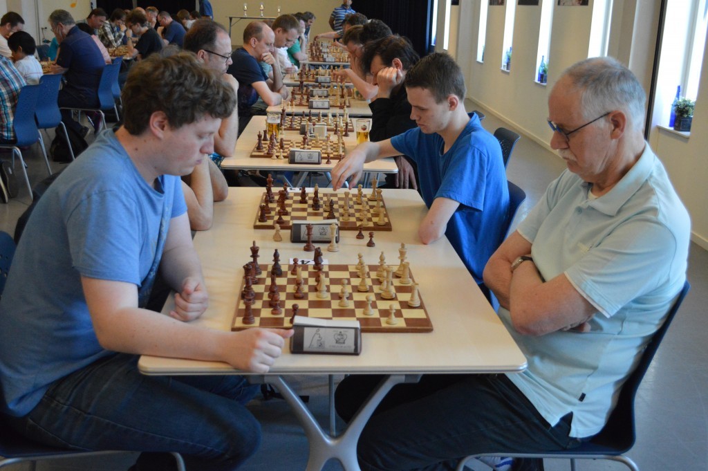 Peter Holscher (Aartswoud + Caïssa-Eenhoorn) start zijn schaakdag tegen Richard van Diepen (zwart, Opening'64 + De Waagtoren).