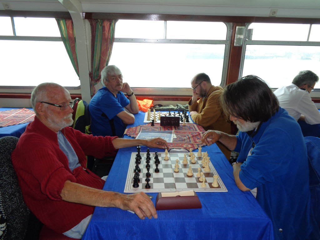 Tjibbe Bijlsma neemt het met zwart op tegen Roel Ridderikhoff en bij het raam zitten Rob Bouwman (links) en Sebastiaan Hol.