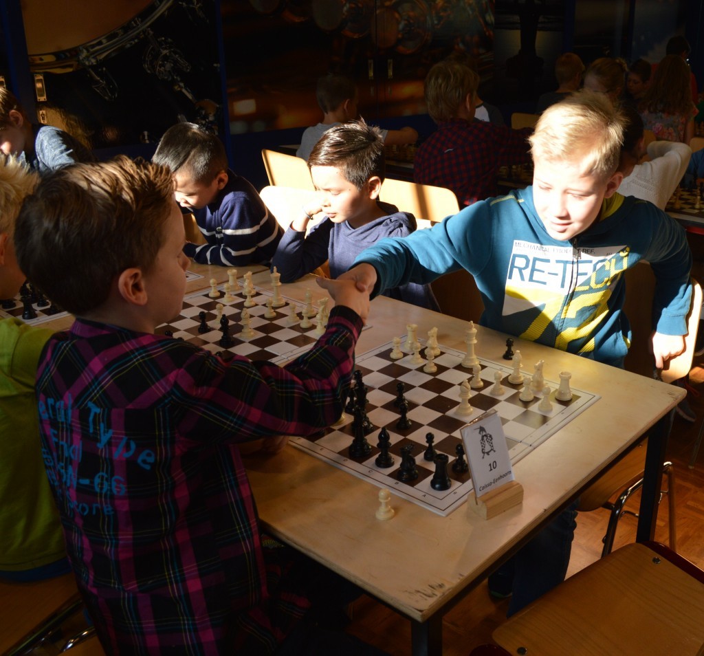 Yoran de Wolff (links) feliciteert Jeffrey Stam die zojuist de matzet heeft uitgevoerd. Wits loper op c4 verdedigt de nauwelijks zichtbare dame f7. De zwarte koning staat op f8.